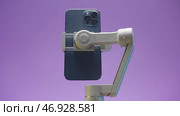 Canada - Ottawa, 11.25.2021: close up of smartphone flexible stabilizer holding new modern device. Редакционное фото, фотограф David Kashakhi / Фотобанк Лори