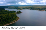 A huge bridge over a large river against the background of a cloudless sky and huge forest trees. Стоковое фото, фотограф David Kashakhi / Фотобанк Лори
