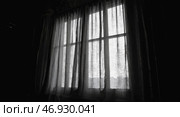 Жутковатая атмосфера с рваной занавеской, покачивающейся в легком ритме в тускло освещенной комнате. Стоковое AI-изображение, AI-художник ФотоИнтеллект / Фотобанк Лори