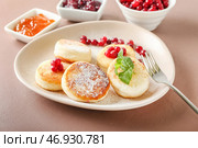 Тарелка с вкусными сырниками и клюквой на столе. Стоковое фото, фотограф Pixel_shot / Фотобанк Лори