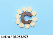 Буква C и витаминные таблетки на цветном фоне. Стоковое фото, фотограф Pixel_shot / Фотобанк Лори