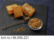 Доска с медовыми сотами и пчелиной пыльцой на черном фоне. Стоковое фото, фотограф Pixel_shot / Фотобанк Лори