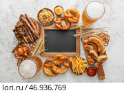 Кружки холодного пива, деревянная доска с баварскими сосисками, пустая доска и закуски на светлом фоне. Празднование Октоберфеста. Стоковое фото, фотограф Pixel_shot / Фотобанк Лори