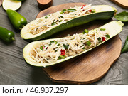 Доска с фаршированными лебедой лодочками из кабачков на деревянном фоне. Стоковое фото, фотограф Pixel_shot / Фотобанк Лори