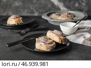 Тарелка с вкусными булочками с корицей на темном фоне. Стоковое фото, фотограф Pixel_shot / Фотобанк Лори
