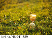Стильные песочные часы на траве на открытом воздухе. Стоковое фото, фотограф Pixel_shot / Фотобанк Лори