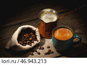 Чашка и джезве с горячим кофе на темном фоне. Стоковое фото, фотограф Pixel_shot / Фотобанк Лори