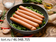 Сковорода с вкусными сосисками и стручковой фасолью на деревянном фоне, крупным планом. Стоковое фото, фотограф Pixel_shot / Фотобанк Лори