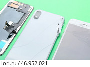 Сломанные мобильные телефоны и модуль дисплея на зеленом фоне, крупным планом. Стоковое фото, фотограф Pixel_shot / Фотобанк Лори