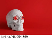 Человеческий череп с фальшивыми глазами на цветном фоне. Стоковое фото, фотограф Pixel_shot / Фотобанк Лори