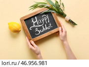 Руки с доской и символами праздника Суккот на цветном фоне. Стоковое фото, фотограф Pixel_shot / Фотобанк Лори