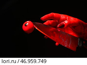 Рука с окровавленным ножом и глазным яблоком на черном фоне. Стоковое фото, фотограф Pixel_shot / Фотобанк Лори