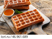 Доска с вкусными бельгийскими вафлями и медом на деревянном фоне, крупным планом. Стоковое фото, фотограф Pixel_shot / Фотобанк Лори