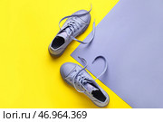 Пара сиреневых туфель с развязанными шнурками на цветном фоне. Стоковое фото, фотограф Pixel_shot / Фотобанк Лори