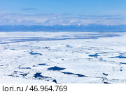 Baikal Lake in May. View from Olkhon Island to the ice drift in the Small Sea. Spring  landscape with mountains in the distance. Natural spring ice floating background. Change seasons. Spring travels. Стоковое фото, фотограф Виктория Катьянова / Фотобанк Лори