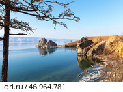 Scenic spring landscape of Baikal Lake on sunny May day. View from coast of Olkhon Island to the famous Shamanka Rock - natural landmark of lake. Natural background. Spring travels and outdoors. Стоковое фото, фотограф Виктория Катьянова / Фотобанк Лори