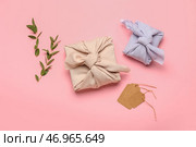 Подарочные коробки, обернутые тканью, бирками и ветками эвкалипта на розовом фоне. Стоковое фото, фотограф Pixel_shot / Фотобанк Лори