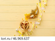 Карнавальная маска и печенье Hamantaschen на праздник Пурим с воздуходувками на цветном деревянном фоне. Стоковое фото, фотограф Pixel_shot / Фотобанк Лори