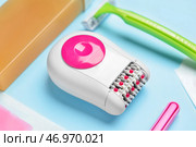 Различные расходные материалы для удаления волос современным эпилятором на синем фоне. Стоковое фото, фотограф Pixel_shot / Фотобанк Лори