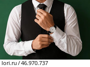 Джентльмен в стильной формальной одежде поправляет рукав на цветном фоне, крупным планом. Стоковое фото, фотограф Pixel_shot / Фотобанк Лори