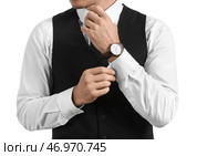 Джентльмен в стильной одежде поправляет рукав на белом фоне, крупным планом. Стоковое фото, фотограф Pixel_shot / Фотобанк Лори