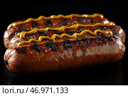 A close-up of juicy, crispy grilled sausages with delicious grill marks. They are covered with a thin layer of mustard, applied in a zigzag pattern. The sausages look shiny and slightly caramelized, which emphasizes their juiciness and rich flavor. The background is dark, which creates a contrast and makes the dish more expressive. The image evokes associations with barbecues, summer picnics and delicious street food. Стоковое AI-изображение, AI-художник Анна Кривицкая / Фотобанк Лори