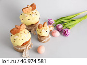 Вкусные пасхальные куличи, украшенные печеньем, цветами и крашеными яйцами на светлом фоне. Стоковое фото, фотограф Pixel_shot / Фотобанк Лори