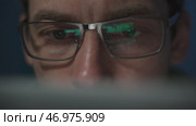 Close-up of a focused coder with glasses. Стоковое видео, видеограф Arsenii Palivoda / Фотобанк Лори