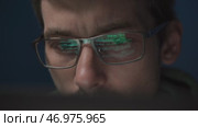 Close-up of a coder in glasses, intently working on a script. Стоковое видео, видеограф Arsenii Palivoda / Фотобанк Лори
