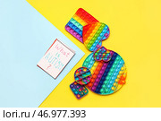 Тетрадь с текстом ЧТО ТАКОЕ АУТИЗМ? и хлопай игрушками на цветном фоне. Стоковое фото, фотограф Pixel_shot / Фотобанк Лори