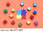 Деревянные кубики с кусочками пазла на красном фоне. Стоковое фото, фотограф Pixel_shot / Фотобанк Лори