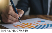 Person Holding a Pen Pointing Colorful Financial Charts, Analysis, Business Activities. Professional is Analyzing a Bar Graph, Data Trends, Report. Businessman Analyzing Document. Growth. Investment. Стоковое AI-видео, аниматор Марина Демидюк / Фотобанк Лори