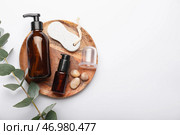 Деревянная тарелка с косметическими средствами, пемзой и вакуумной банкой для антицеллюлитного массажа на белом фоне. Стоковое фото, фотограф Pixel_shot / Фотобанк Лори