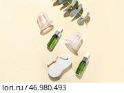 Композиция с бутылочками эфирного масла, пемзой и вакуумными баночками для антицеллюлитного массажа на цветном фоне. Стоковое фото, фотограф Pixel_shot / Фотобанк Лори