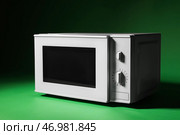 Белая микроволновая печь с открытой дверцей на зеленом фоне. Стоковое фото, фотограф Pixel_shot / Фотобанк Лори