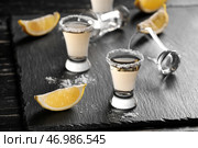 Шоты вкусной мексиканской текилы с лимоном на столе. Стоковое фото, фотограф Pixel_shot / Фотобанк Лори