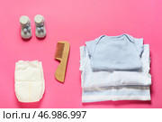 Детская одежда, подгузники и деревянный гребень для волос на розовом фоне. Стоковое фото, фотограф Pixel_shot / Фотобанк Лори