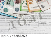 Долговая квитанция на оплату коммунальных услуг и деньги. Редакционное фото, фотограф Игорь Низов / Фотобанк Лори