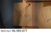 Mysterious word in rebus from notes on board with red thread. Стоковое фото, фотограф David Kashakhi / Фотобанк Лори