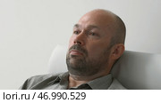 Man in sadness and depression with devastated expression at psychologist. Стоковое фото, фотограф David Kashakhi / Фотобанк Лори