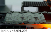 Close up of industrial background with printed circuit board being assembled with automated robotic arm. Стоковое фото, фотограф David Kashakhi / Фотобанк Лори