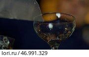 Close up of bartender putting large cubes of ice nto the empty vintage glass. Стоковое фото, фотограф David Kashakhi / Фотобанк Лори