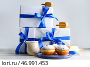 Подарки для празднования Хануки, вкусные пончики и крутильные вертящиеся стручки на светлом фоне. Стоковое фото, фотограф Pixel_shot / Фотобанк Лори