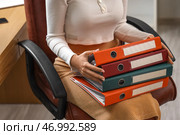 Молодая бизнес-леди с папками документов сидит в офисе, крупным планом. Стоковое фото, фотограф Pixel_shot / Фотобанк Лори