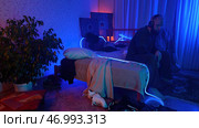 Worried, tired man sitting on bed at night and listening to music. Стоковое фото, фотограф David Kashakhi / Фотобанк Лори