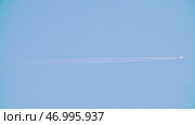 A magnificent airplane soaring through the clear blue sky, leaving behind a white contrail. Стоковое фото, фотограф David Kashakhi / Фотобанк Лори