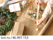 Молодая женщина заворачивает подарок на столе, вид сверху. Стоковое фото, фотограф Pixel_shot / Фотобанк Лори