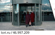Glass rotating door, turntable entrance to the business center, time lapse. Стоковое фото, фотограф David Kashakhi / Фотобанк Лори