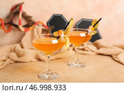 Стаканы вкусного апельсинового коктейля для Хэллоуина с физалисами и пауками на бежевом фоне, крупным планом. Стоковое фото, фотограф Pixel_shot / Фотобанк Лори