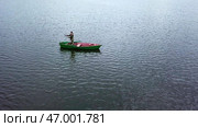 A solo kayaker glides across the tranquil lake, enjoying natures beauty and peace. Стоковое фото, фотограф David Kashakhi / Фотобанк Лори